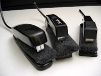 three black staplers on a white surface