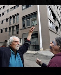 two men standing in front of a building
